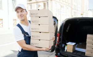 Courier delivery a male driver delivers orders in boxes to the house. Uniform and cap for an employe